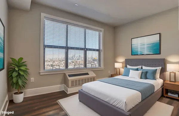 a bedroom with a large bed and a potted plant