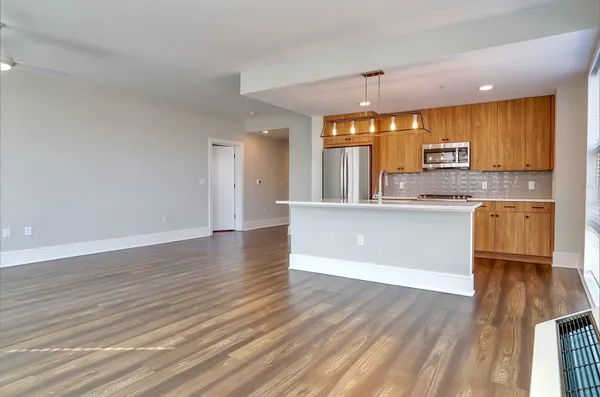 a kitchen with granite countertop wooden floors and white cabinets