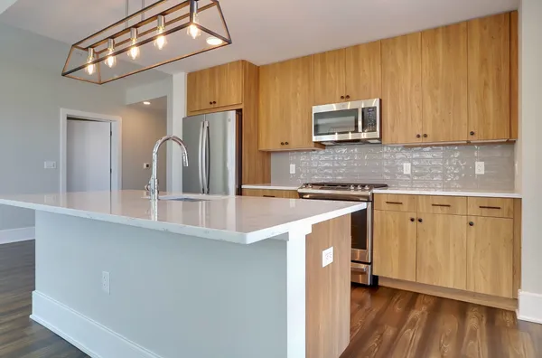 a kitchen with stainless steel appliances granite countertop a sink a stove and refrigerator