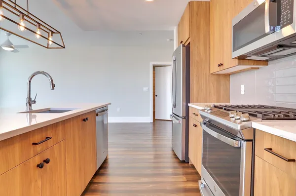 a kitchen with stainless steel appliances a stove and a wooden floor