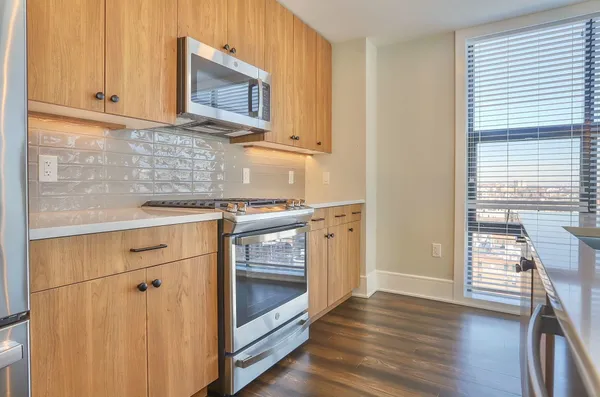 a kitchen with stainless steel appliances granite countertop a stove a sink and a microwave