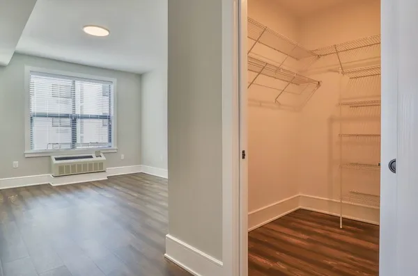 an empty room with wooden floor and windows