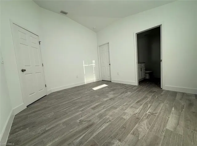 a view of an empty room with wooden floor