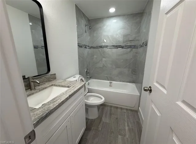 a bathroom with a granite countertop sink toilet and shower