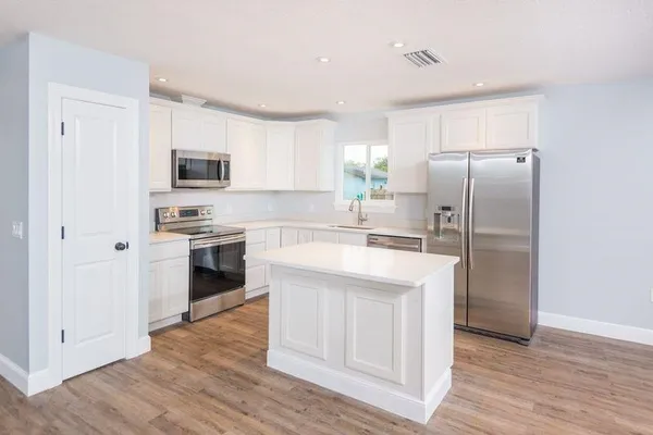 a kitchen with stainless steel appliances a refrigerator sink and microwave