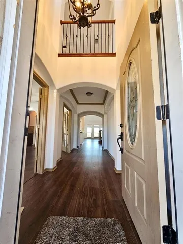 a view of a hallway with wooden floor and stairs