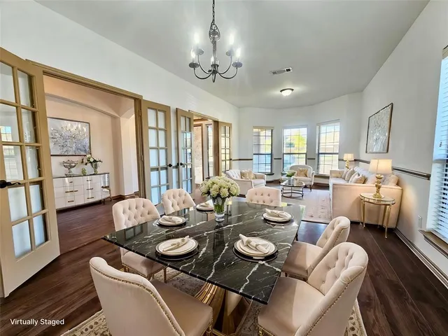 a dining room with furniture a chandelier and wooden floor