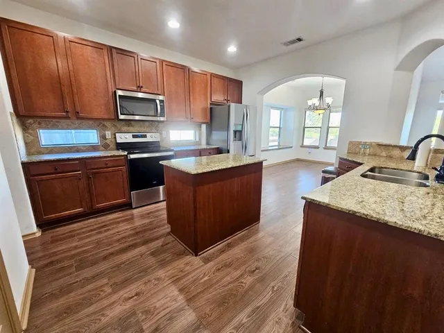 a kitchen with stainless steel appliances granite countertop a sink stove and microwave