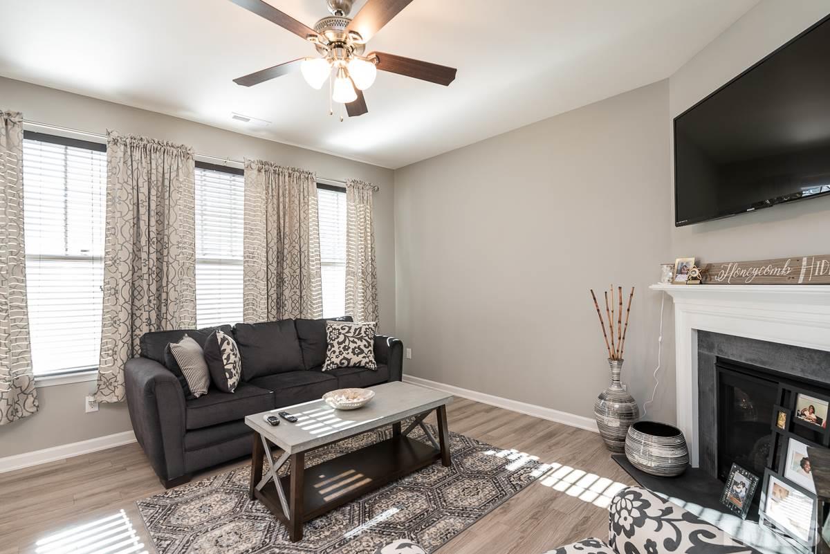 718 Maypearl Lane Raleigh, NC 27610 - Photo 8 of 23 a living room with furniture a flat screen tv and a fireplace