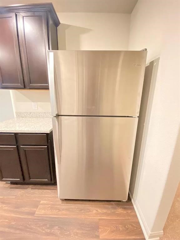 213 Allington Circle Jarrell, TX 76537 - Photo 14 of 16 a view of a refrigerator in kitchen and wooden floor