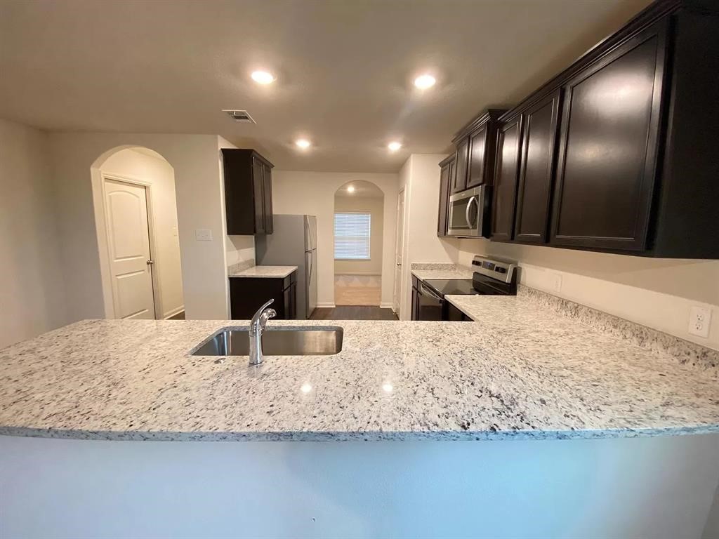 213 Allington Circle Jarrell, TX 76537 - Photo 16 of 16 a large kitchen with granite countertop a large counter top sink and stainless steel appliances