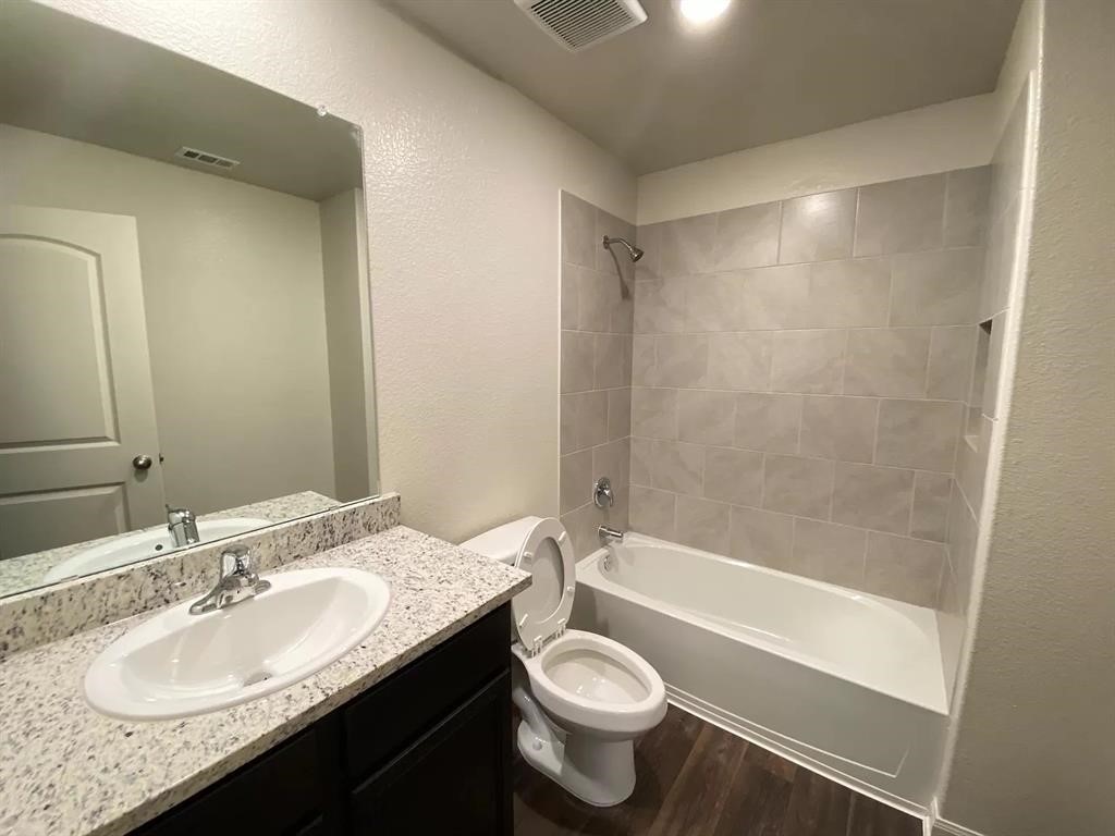 213 Allington Circle Jarrell, TX 76537 - Photo 6 of 16 a bathroom with a granite countertop sink toilet and shower