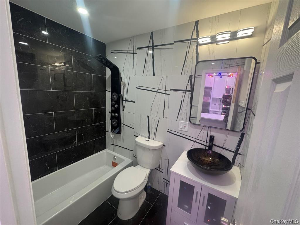 152 Evans Avenue Freeport, NY 11520 - Photo 11 of 12 Full bath featuring vanity, tile walls, and shower / washtub combination