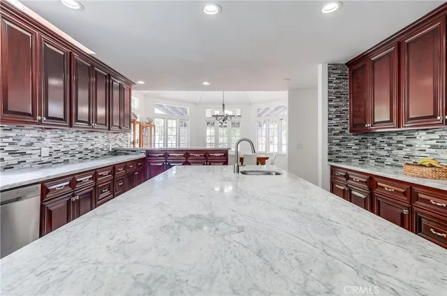 a large kitchen with stainless steel appliances wooden cabinets a stove and a sink