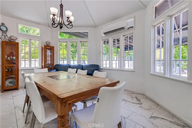 a view of a dining room with furniture a livingroom and chandelier