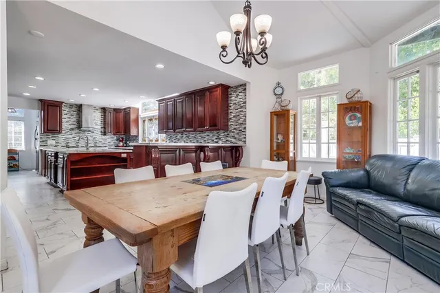a view of a dining room with furniture a livingroom and chandelier