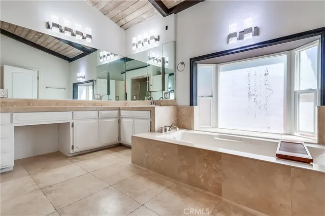 a large white kitchen with a large window cabinets and stainless steel appliances