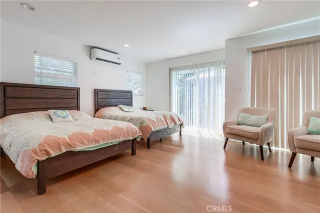 a spacious bedroom with a bed and chair