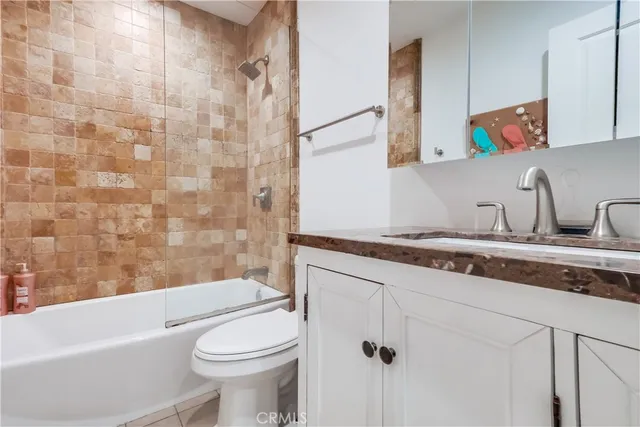 a bathroom with a granite countertop sink a toilet and bathtub