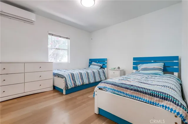 a bedroom with two beds and window