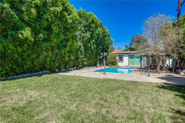 a view of a house with backyard and sitting area