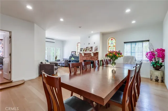 a view of a dining room and livingroom with furniture wooden floor a potted plant and a chandelier