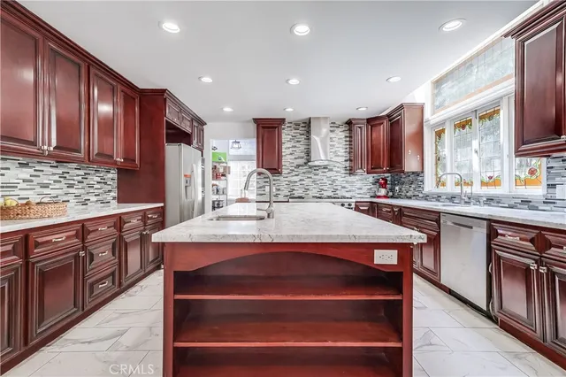 a kitchen with kitchen island granite countertop wooden cabinets a stove top oven a sink and dishwasher