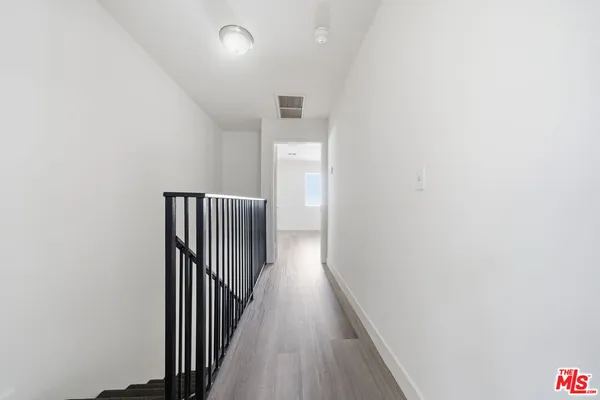 a view of a hallway with wooden floor and staircase