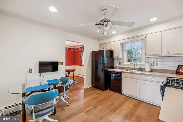 a kitchen with stainless steel appliances kitchen island granite countertop a refrigerator a stove a sink dishwasher a dining table and chairs with wooden floor