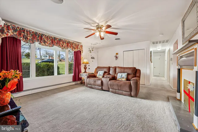 a living room with furniture a flat screen tv and a large window