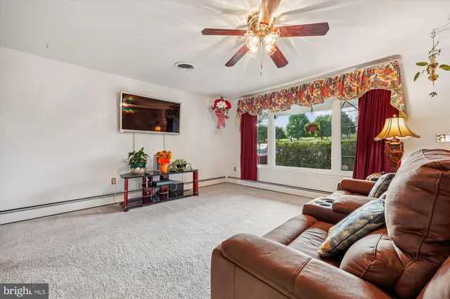 a living room with furniture a window and a flat screen tv