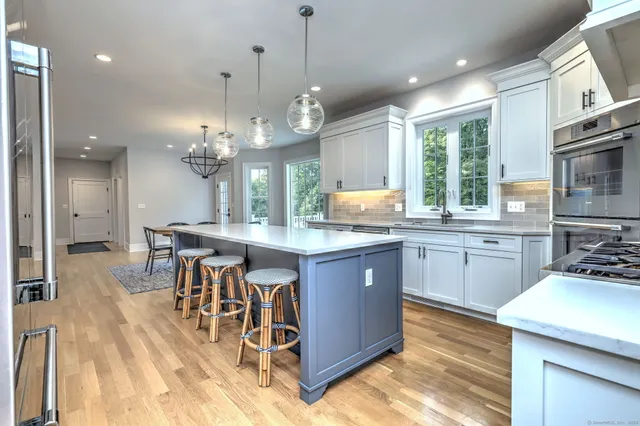 a large kitchen with lots of counter space dining table and stainless steel appliances