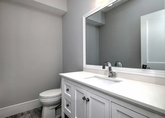 a bathroom with a sink a toilet and mirror
