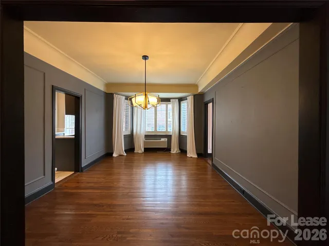 a view of a livingroom with wooden floor and a window