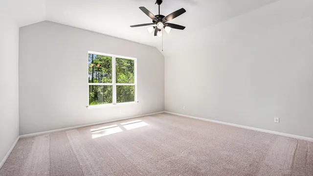 an empty room with a window and a fan