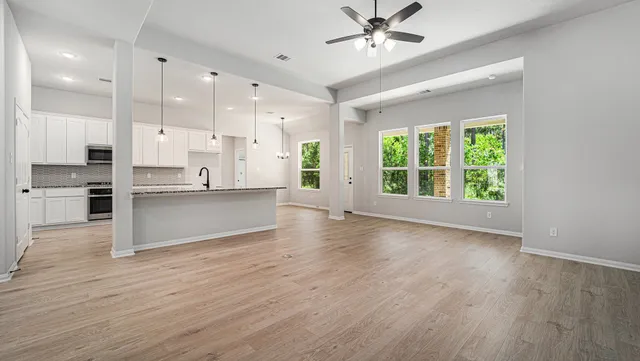 a view of a kitchen with wooden floor and a window