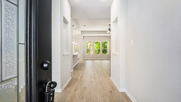 a view of a hallway with wooden floor and staircase