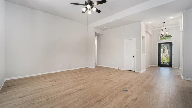 a view of a livingroom with wooden floor and a ceiling fan