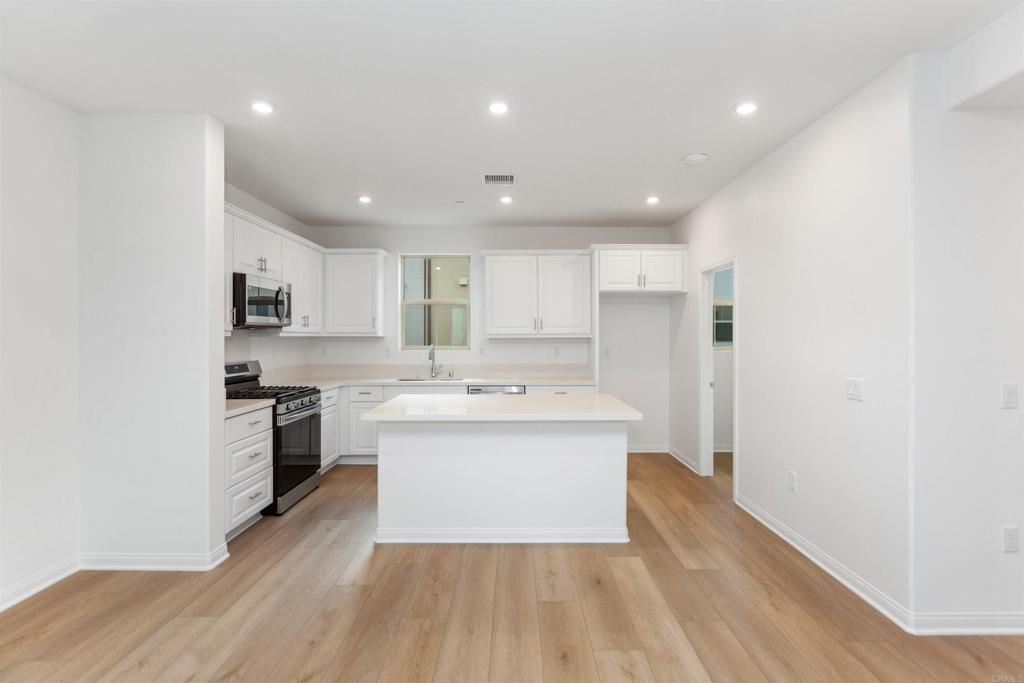 1532 Redbud Way Oceanside, CA 92056 - Photo 2 of 40 a large kitchen with a sink and stainless steel appliances