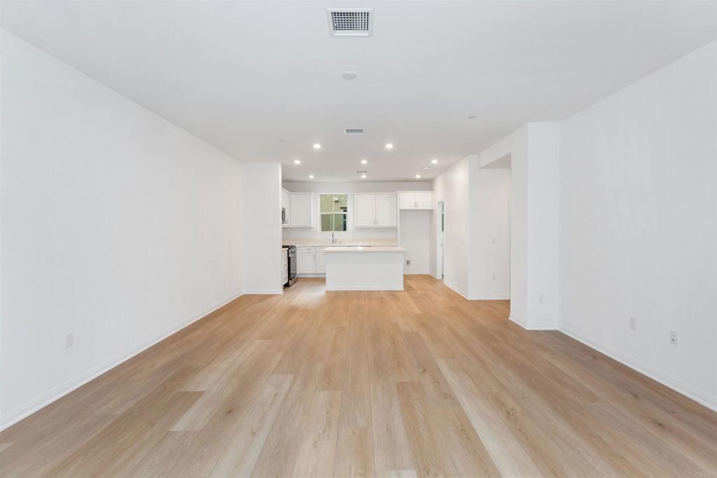 1532 Redbud Way Oceanside, CA 92056 - Photo 29 of 40 a view of kitchen and empty room with wooden floor