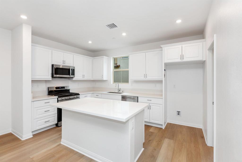 1532 Redbud Way Oceanside, CA 92056 - Photo 3 of 40 a kitchen with a stove a sink and a refrigerator
