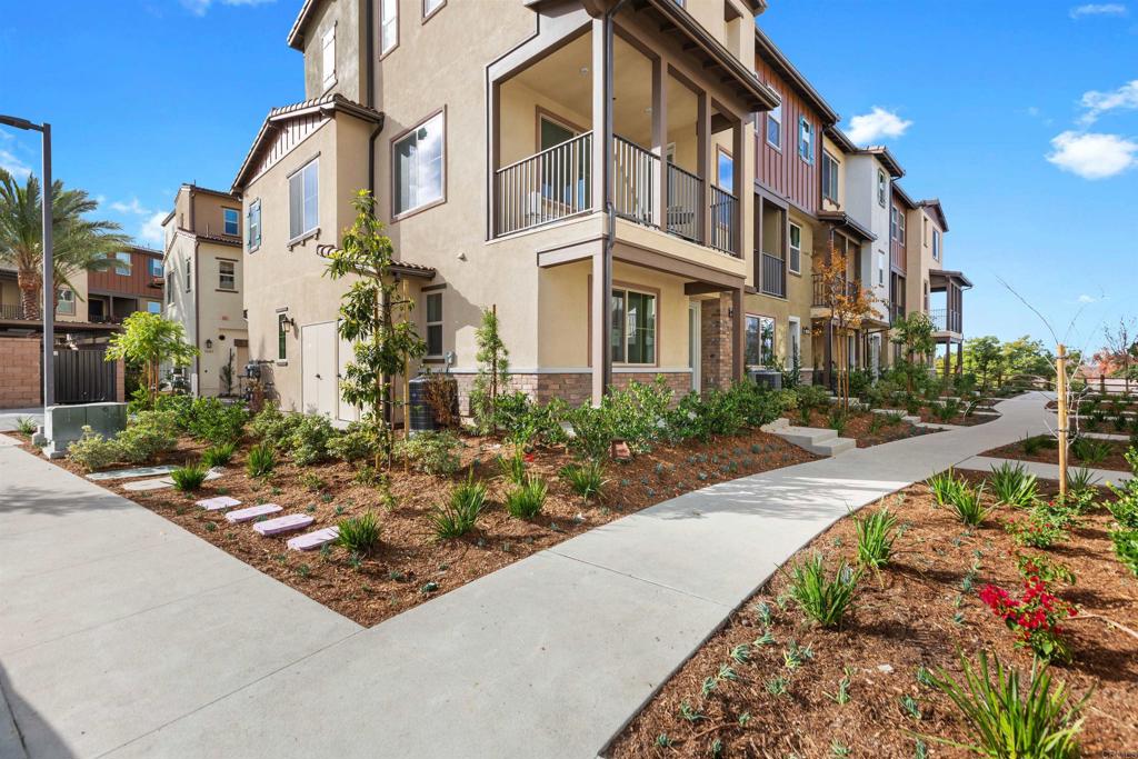 1532 Redbud Way Oceanside, CA 92056 - Photo 35 of 40 a front view of a multi story residential apartment building with yard and parking