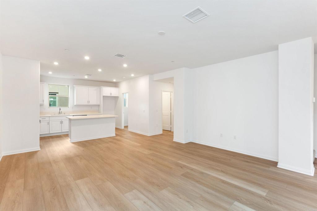 1532 Redbud Way Oceanside, CA 92056 - Photo 5 of 40 a view of a kitchen with kitchen island white cabinets and wooden floor