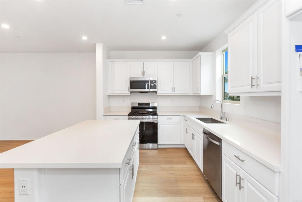1532 Redbud Way Oceanside, CA 92056 - Photo 7 of 40 a kitchen with a sink a stove top oven and white kitchen