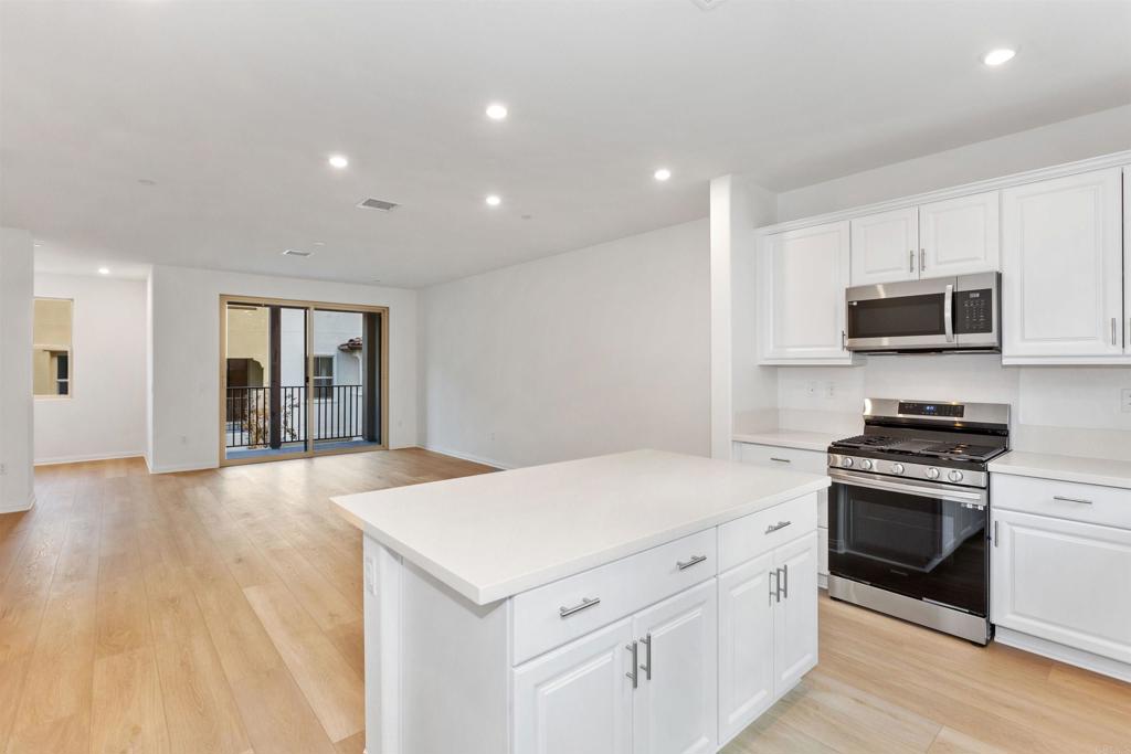 1532 Redbud Way Oceanside, CA 92056 - Photo 9 of 40 a kitchen with stainless steel appliances a stove a sink a microwave a refrigerator and cabinets