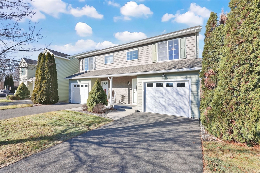 a front view of a house with a yard and potted plants