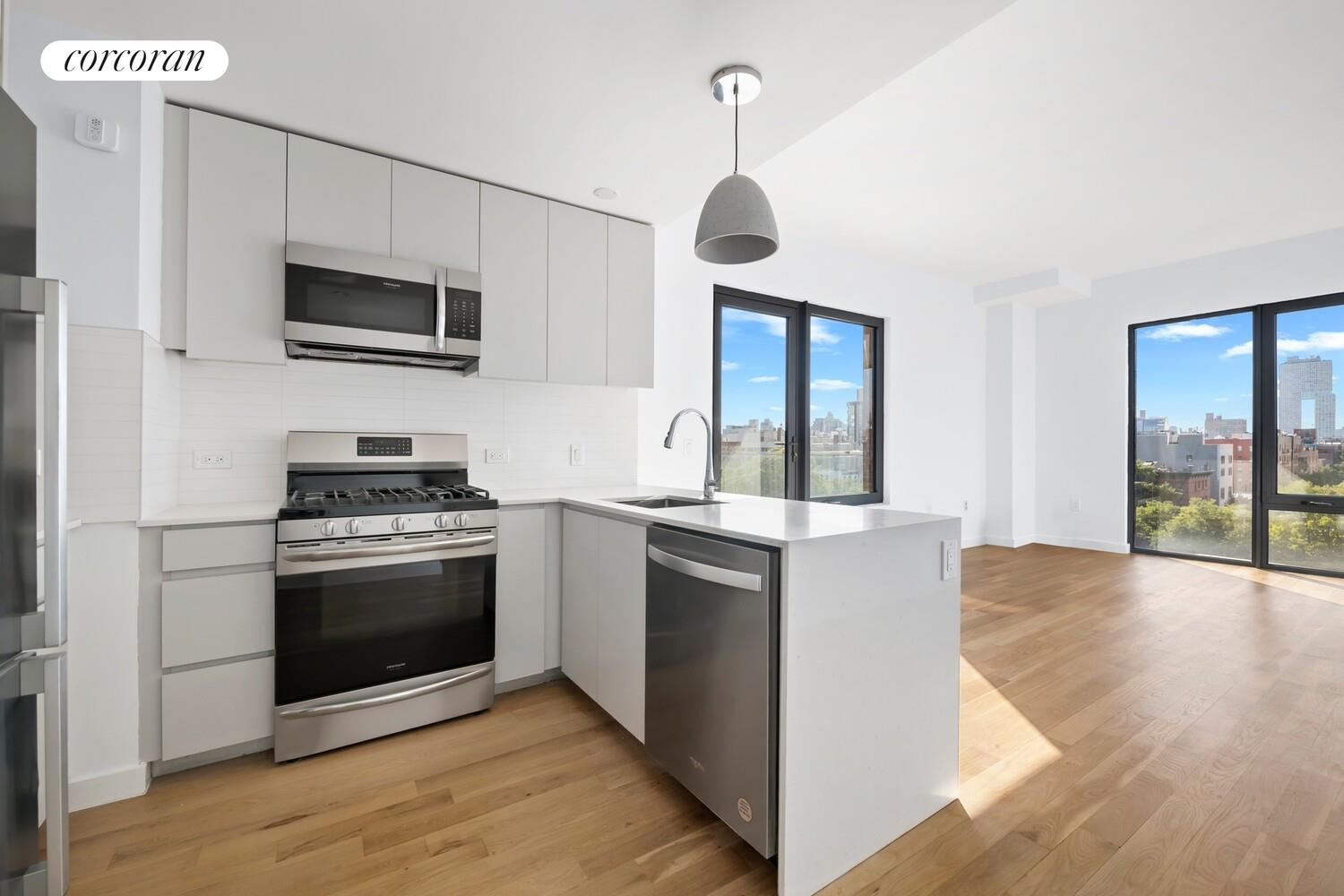 123 Hope Street, Unit 7R Brooklyn, NY 11211 - Photo 4 of 15 a kitchen with stainless steel appliances granite countertop a stove and a microwave