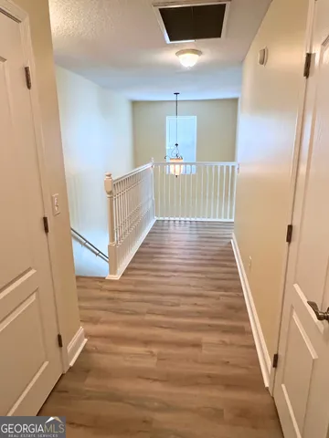 a view of a hallway view with wooden floor and staircase
