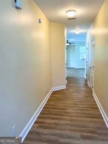 a view of a hallway with wooden floor
