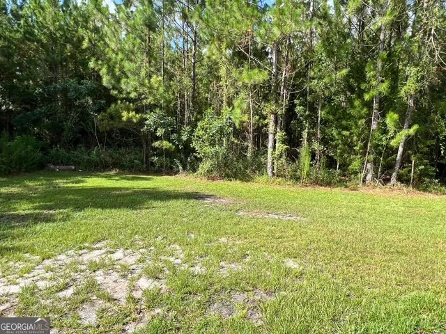 a backyard of a house with lots of green space and fountain